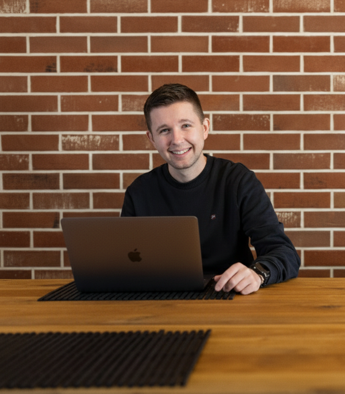 Portrét Marcela Zábojníka, marketingového specialisty a konzultanta. Sedí v homeoffice kanceláři v šedé košili a hodinkami.